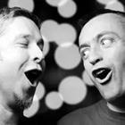 A black and white photo of two men singing