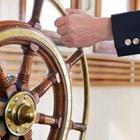 A hand on a ship’s steering wheel
