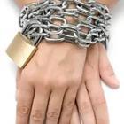 A person’s hands tied by chains and a gold lock