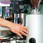 A person’s hand touching a grey machine, cofe