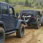 Two black jeeps on a dirt road