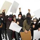 A group of people in masks holding up signs
