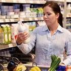 A woman food shopping and holding something up