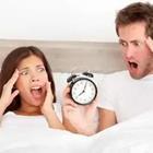 Couple in bed with alarm clock