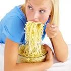 Girl shoveling noodles in her mouth