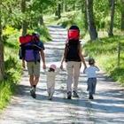 A family walking on a path with the adults carrying backpacks