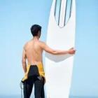 A man holding up a surfboard