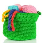 A green basket filled with wool