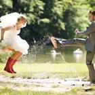 Bride and groom playing in a puddle