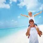 Son on fathers shoulders on beach