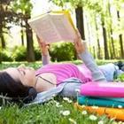 Girl reading book on grass