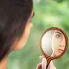 A woman looking at herself in the mirror