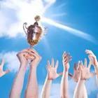 People’s arms raised in the air holding up a trophy