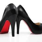 A pair of black heeled shoes with a red bottom