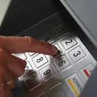 A person’s finger touching a keypad, atm pin