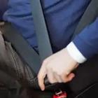 A person putting their seatbelt on