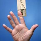 A person’s finger caught inside of a mousetrap