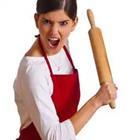 A woman holding a rolling pin with her mouth opened