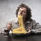 A man stuffing his face with pasta