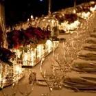 A big table with glasses and flowers going across