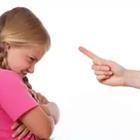 A child with their arms folded and someone pointing their finger at them