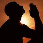 A person praying in the sunset