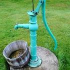 A blue water pump with a bucket under it