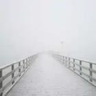 A bridge with snow and fog on it