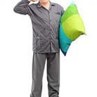 A person in pajamas and holding a pillow