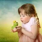 A little girl holding a green frog