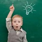 Child in front of green chalkboard with light bulb