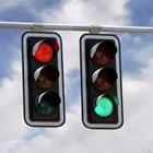 Two street lights. One with a red light and one with a green light