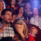 A man and woman in the movie theater and the woman is looking away from the screen