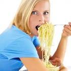 A woman stuffing her face with pasta