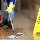 A person cleaning the floors with a mop