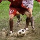 Two people soccer in the mud