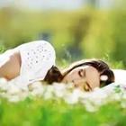 Girl sleeping in the grass with flowers