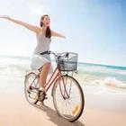 Woman riding bike on beach