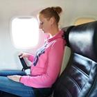 A woman wearing her seatbelt on a plane
